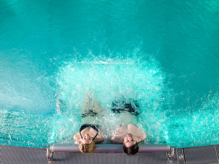 Zwei Personen schwimmen in einem Pool in der Wasserwelt des Landhauses Sponsel-Regus in Franken