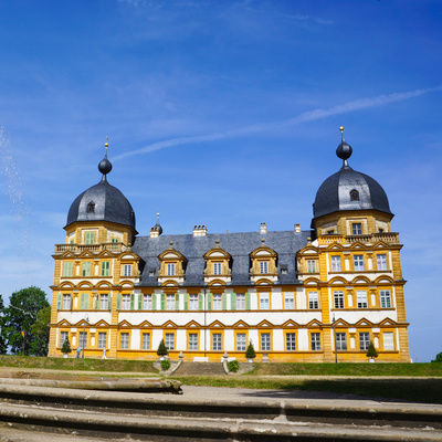 Das beeindruckende Schloss Seehof mit kunstvollen Details und einem Brunnen im Vordergrund.