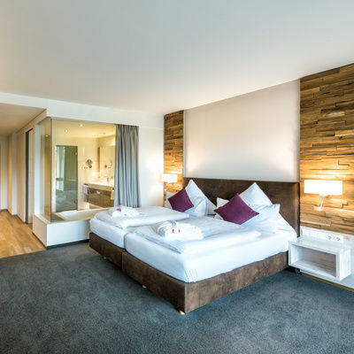 Das geräumige Schlafzimmer mit großem Bett und edlen Möbeln in der Juniorsuite Schloessla im Hotel Sponsel-Regus