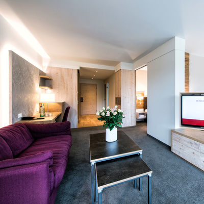 Ein geschmackvoll eingerichtetes Wohnzimmer im Landhaus Sponsel-Regus mit Holzboden und einem Flachbildfernseher.