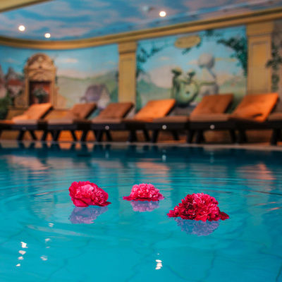 Blumen schwimmen im hellen Blau des Pools im Sponsel-Regus Hotel in Franken.