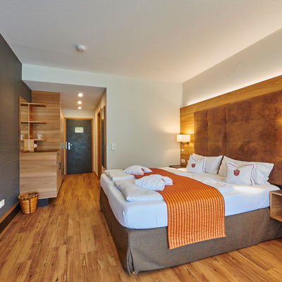 Elegante Holzmöbel ergänzen das stilvolle Design des Komfortdoppelzimmer im Haus Sonneck