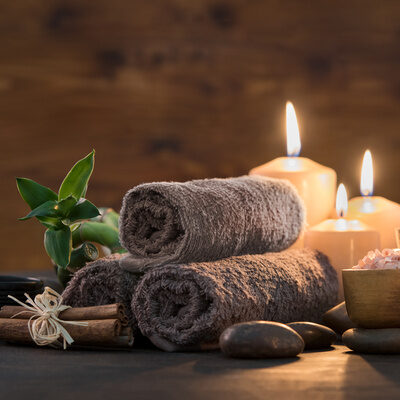 Sanftes Kerzenlicht und weiche Handtücher schaffen ein Gefühl von Wellness.