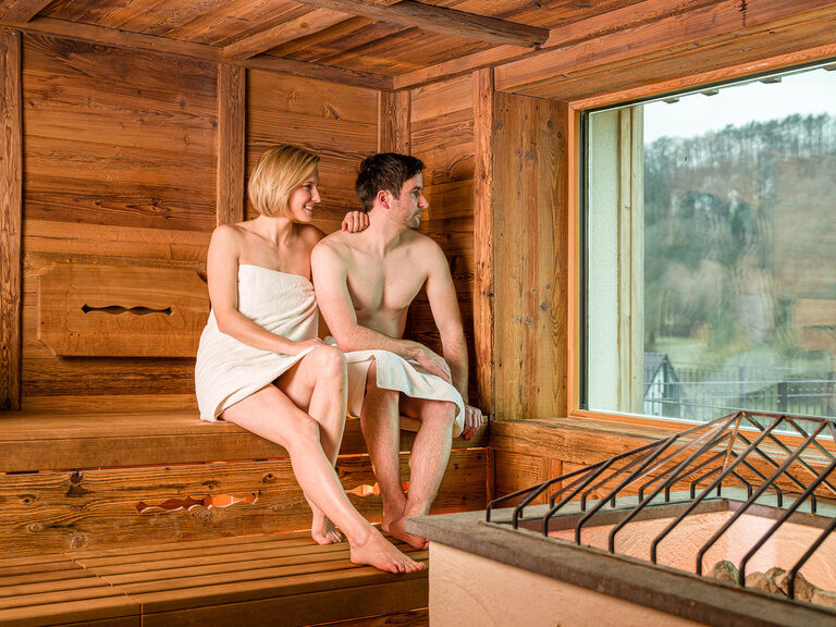Ein Mann und eine Frau genießen die Zeit gemeinsam in einer Sauna im Hotel Sponsel-Regus in der Fränkischen Schweiz