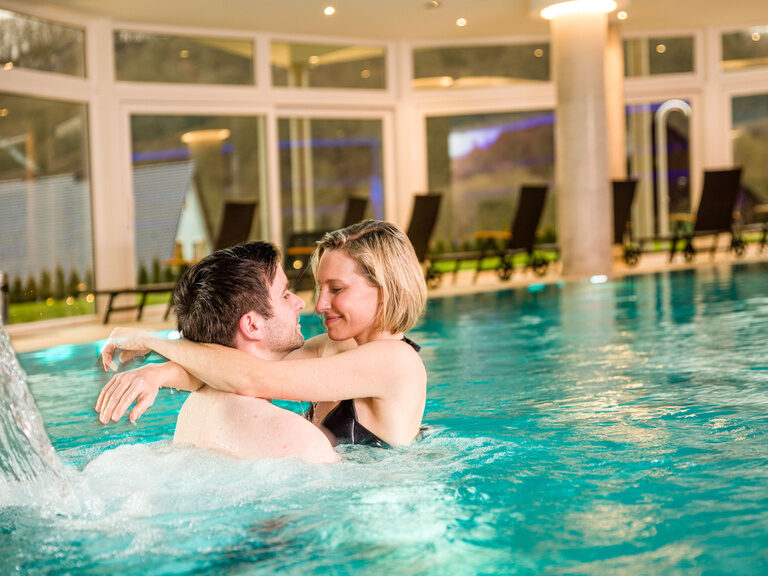 Ein Mann und eine Frau genießen die Zeit in einem Pool der Wasserwelt Schlössla des Hotels Sponsel-Regus