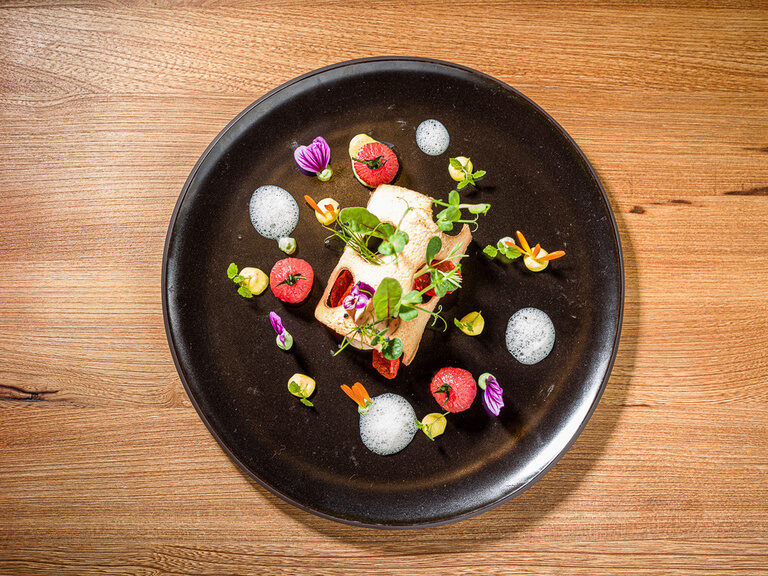 Ein farbenfrohes, ansprechendes Gericht auf einem Teller auf Holztisch