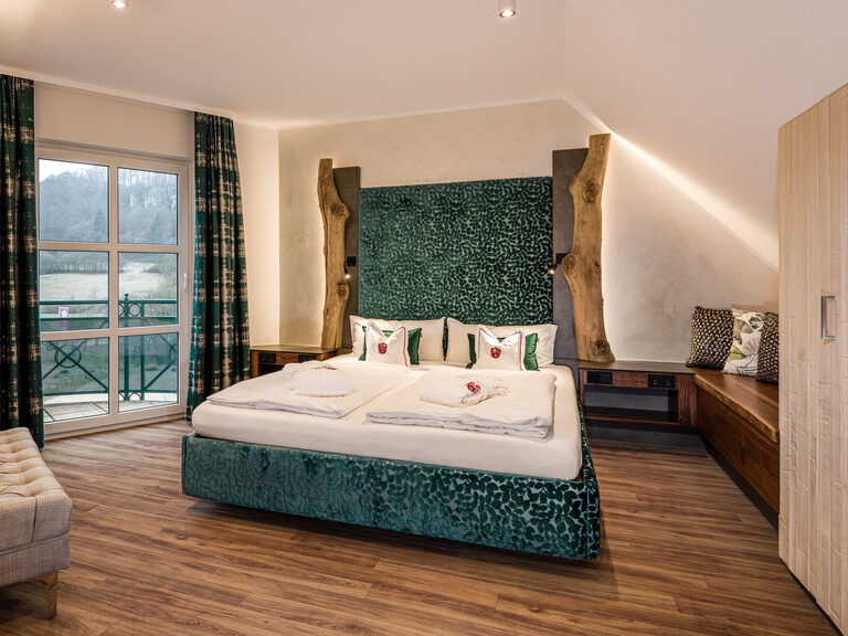 Die geräumige Suite Mattstein mit Holzfußboden und einem komfortablen Doppelbett.