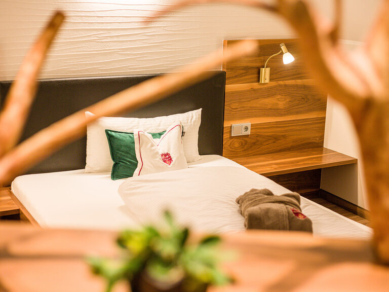 Das Zimmer hat ein Bett mit einem hölzernen Kopfteil.