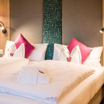 Zwei Betten mit bequemen Kissen und edle Möbel in einem Hotelzimmer im Landhaus Sponsel-Regus
