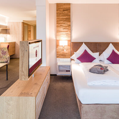 Das helle und geräumige Schlafzimmer der Turm-Suite Schlössla mit Holzmöbeln und großem Bett