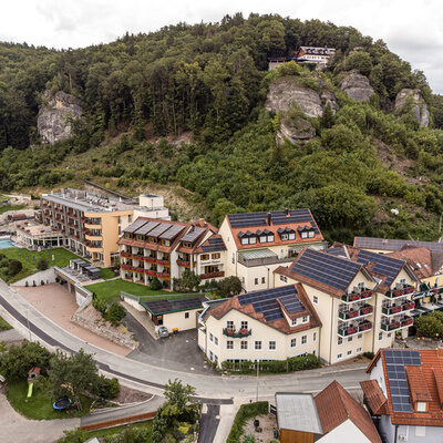 Das Hotel Sponsel-Regus in Franken aus der Luft mit Wald und Bergen im Hintergrund