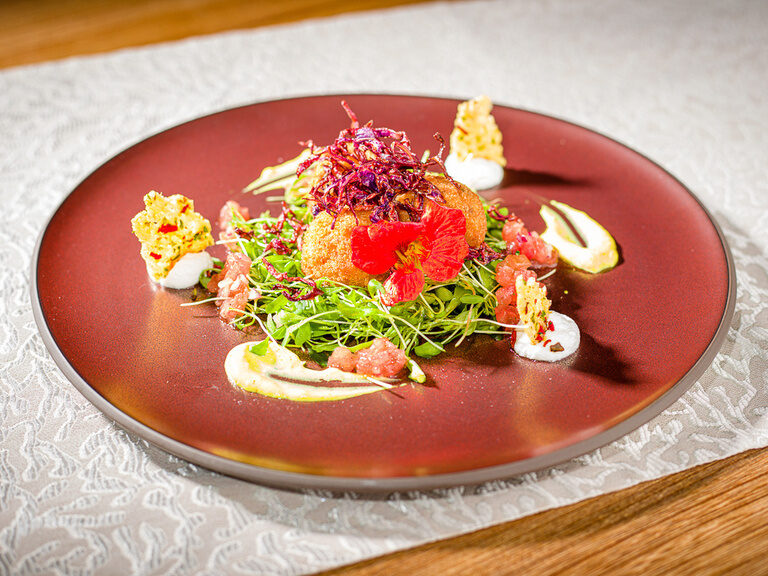 Ein kunstvoll angerichtetes Gericht auf einem eleganten Teller im Spa-Hotel Fränkische Schweiz