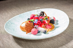 Ein weißer Teller mit Früchten und Beeren