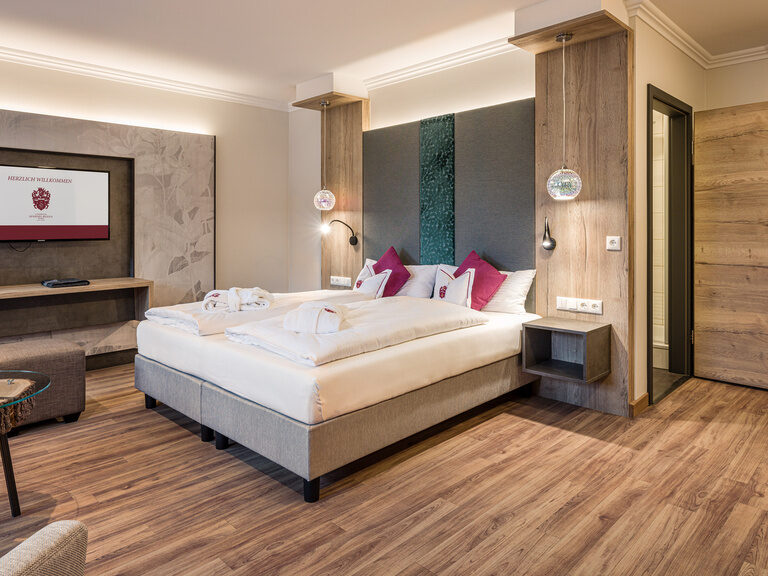 Das Zimmer verfügt über ein großes Bett und Holzboden.