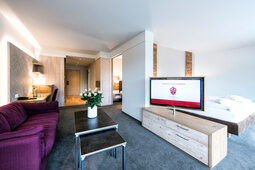 Ein geschmackvoll eingerichtetes Wohnzimmer im Landhaus Sponsel-Regus mit Holzboden und einem Flachbildfernseher.