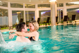Ein Mann und eine Frau genießen die Zeit in einem Pool der Wasserwelt Schlössla des Hotels Sponsel-Regus