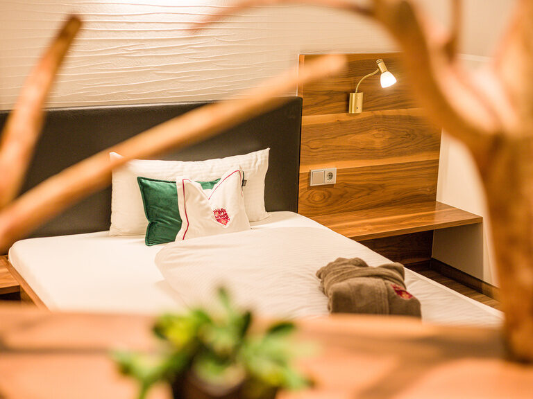 Das Zimmer hat ein Bett mit einem hölzernen Kopfteil.