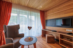Ein geschmackvoll eingerichtetes Hotelzimmer mit einem Flachbildfernseher und Holzboden.