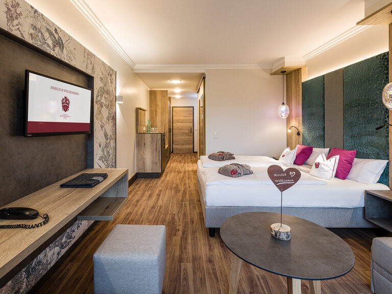 Moderne Einrichtung sowie edle Möbel und ein großes Bett im Komfort Doppelzimmer im Hotel Sponsel-Regus in Franken