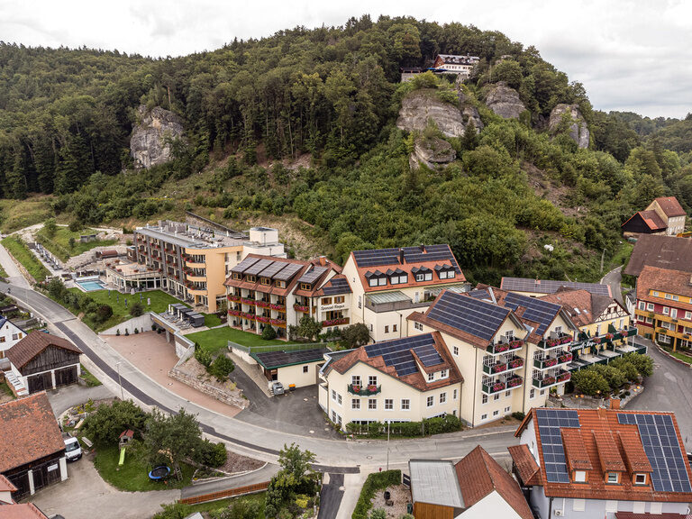 Das Hotel Sponsel-Regus in Franken aus der Luft mit Wald und Bergen im Hintergrund