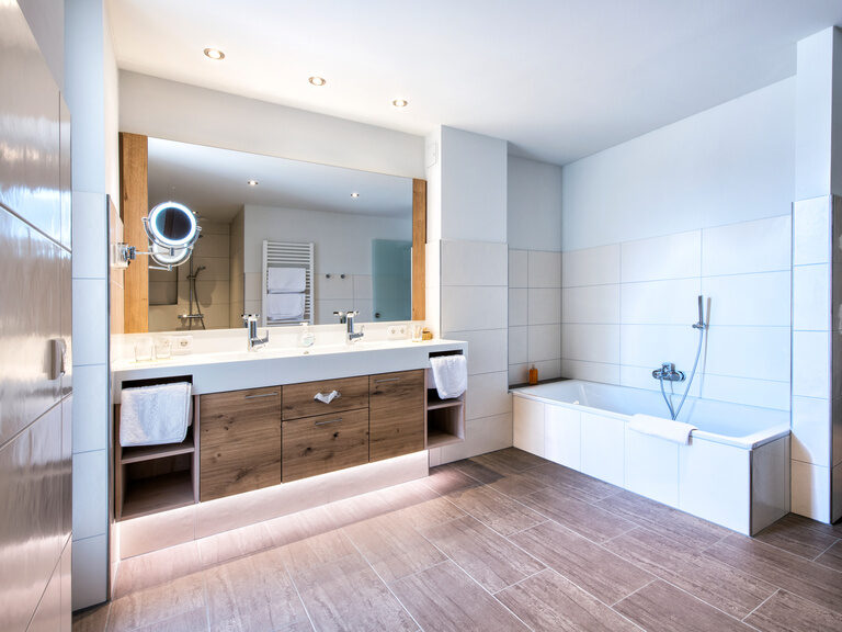 Helles Badezimmer mit modernen Waschbecken und echtem Holzfußboden.