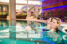 Ein paar relaxt gemeinsam in einem Pool in der Wasserwelt des Hotels Sponsel-Regus in Franken