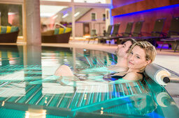 Ein Paar liegt entspannt in einem Swimmingpool des Hotels Sponsel-Regus in der Fränkischen Schweiz