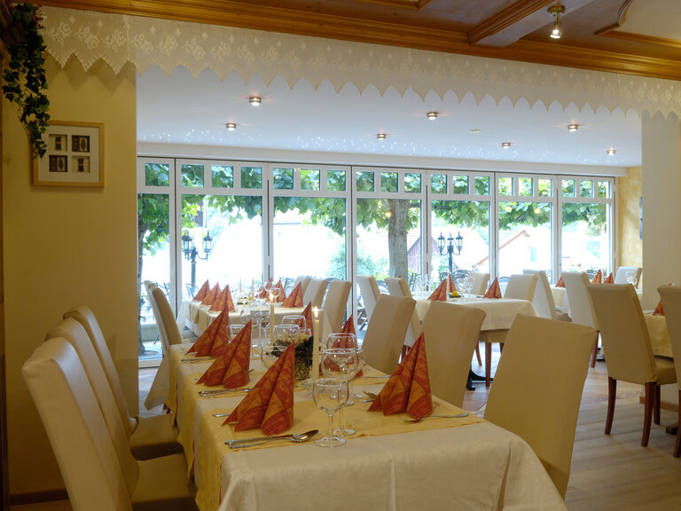 Ein modernes Restaurant mit elegantem Interieurdesign und weiß gedeckten Tischen im Hotel Sponsel-Regus