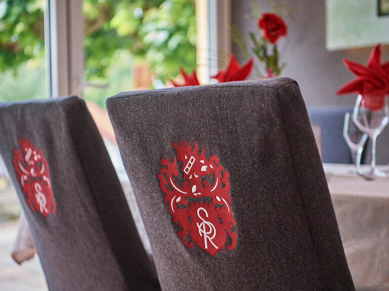 Zwei Stühle mit dem Signet des Hotels Sponsel-Regus auf der Rückseite