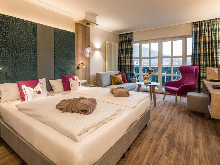 Edle moderne Möbel und ein großes Bett im hellen Schlafensbereich des Komfort Doppelzimmer im Haus Mattstein