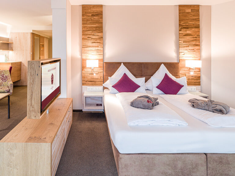 Das helle und geräumige Schlafzimmer der Turm-Suite Schlössla mit Holzmöbeln und großem Bett