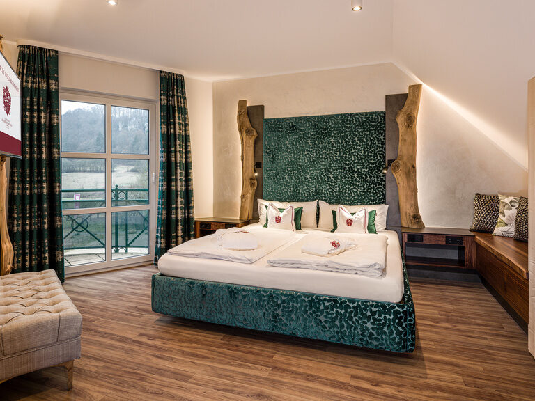 Die geräumige Suite Mattstein mit Holzfußboden und einem komfortablen Doppelbett.