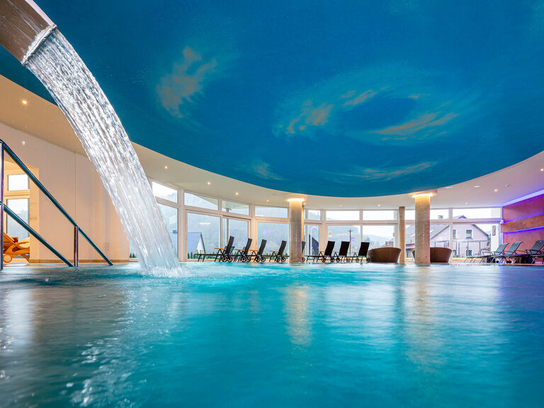 Der große hellblaue Innenpool lädt zur Entspannung ein im Hotel in Franken