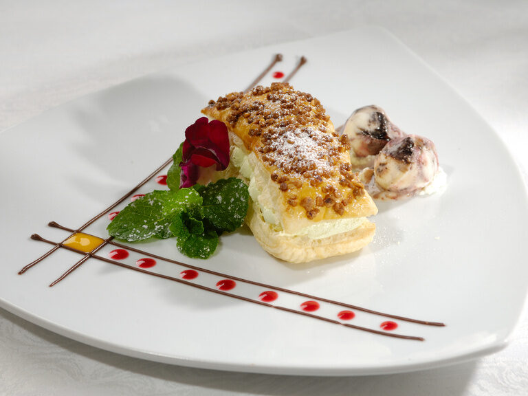 Ein weißer Teller mit einem kunstvoll dekorierten Buttercreme-Kuchen