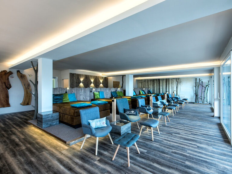 Ein elegant möblierter Ruhebereich im Wellnesshotel mit Holzboden und großer Fensterfront