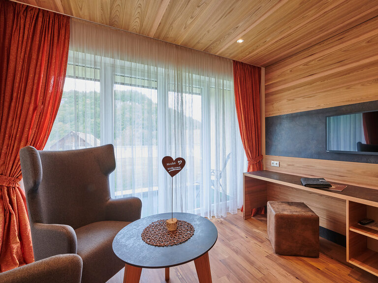 Hochwertige Holzmöbel, kuschelige Sessel und eine entspannende Atmosphäre im Komfortdoppelzimmer im Haus Sonneck