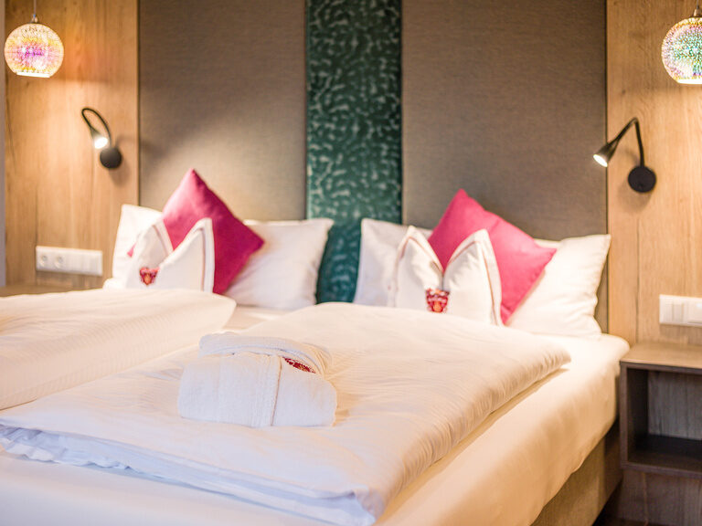 Zwei Betten mit bequemen Kissen und edle Möbel in einem Hotelzimmer im Landhaus Sponsel-Regus